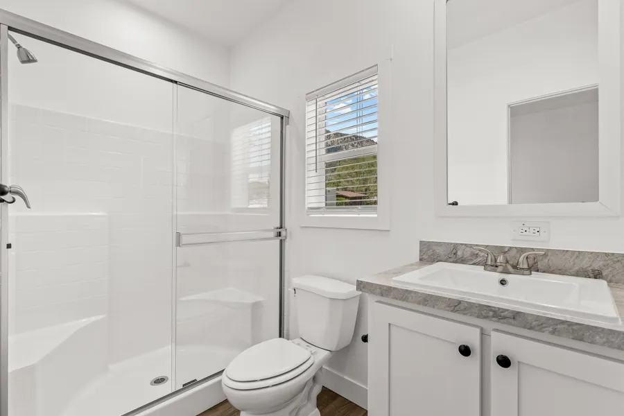 Primary bathroom with a shower and vanity, Mt. Elden visible through the window