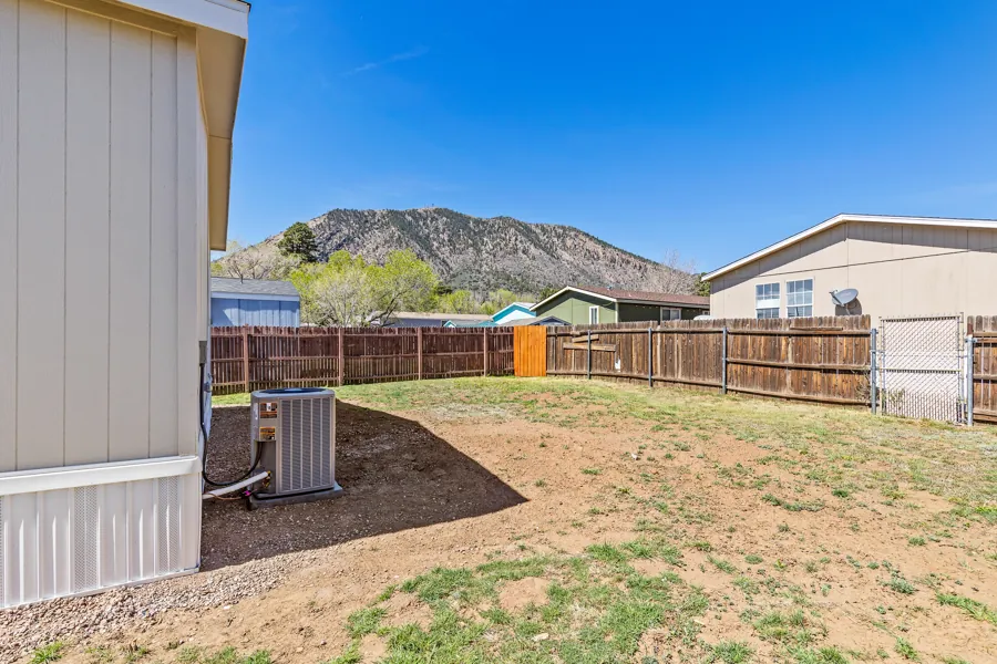 A fenced Jo Don backyard with a view of Mt. Elden