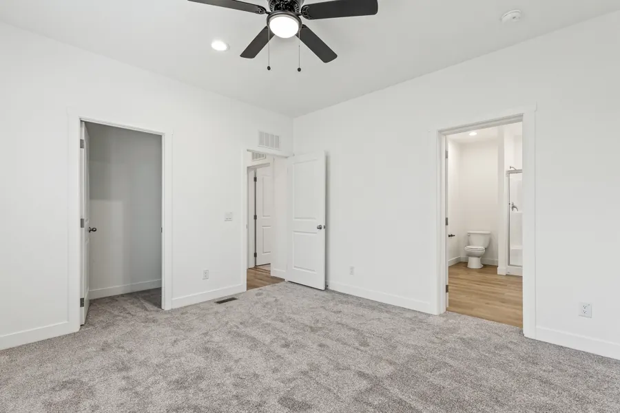 Primary bedroom with carpet and a ceiling fan